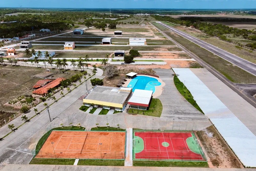 Vista aérea do condomínio com piscina, quadras e pista de pouso