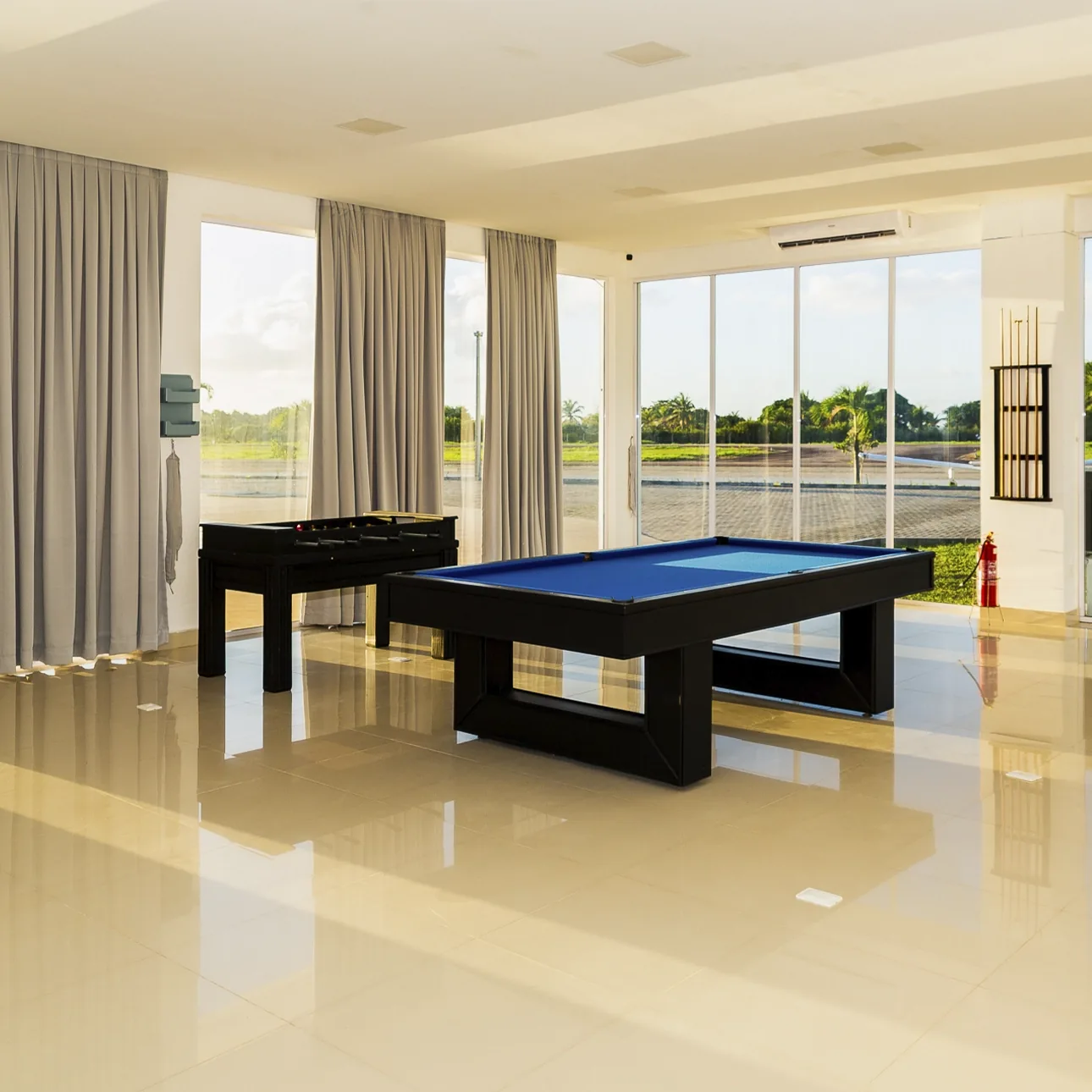 Salão de jogos com mesa de sinuca e pebolim